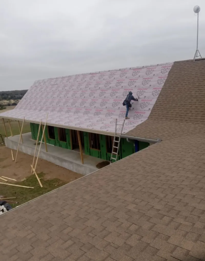Worker preparing underlayment for a metal roof installation in Cookeville